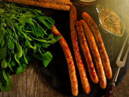 Grilled sausages and stewed cabbage on a wooden table. Rustic style. Snacks for the Oktoberfest. Top view.の写真素材