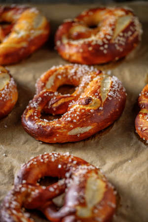 Freshly baked home soft pretzel with salt on craft paper for bakingの写真素材