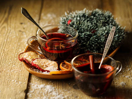 Christmas hot mulled wine with orange, cinnamon, cardamom and anise on wooden backgroundの写真素材