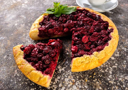 Pie with a cherry on the table with a cup of coffee.の写真素材