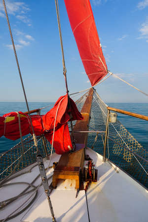 Yacht with red sails in the open seaの写真素材
