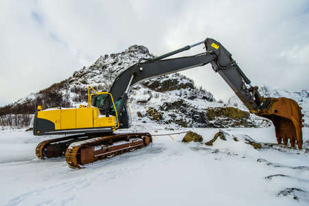 Large yellow excavator on the background of a winter landscape.の写真素材