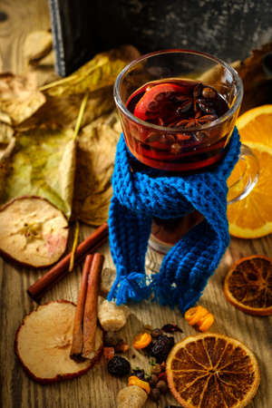 Christmas hot mulled wine with orange, cinnamon, cardamom and anise on wooden background.の写真素材