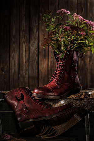 Brown leather women's boots on a wooden background.の写真素材