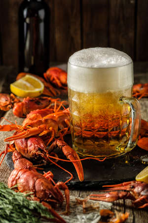 Fresh boiled crawfish and a mug of beer on a wooden tableの写真素材