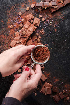 Chocolatier sprinkles pieces of chocolate cocoa powder.の写真素材