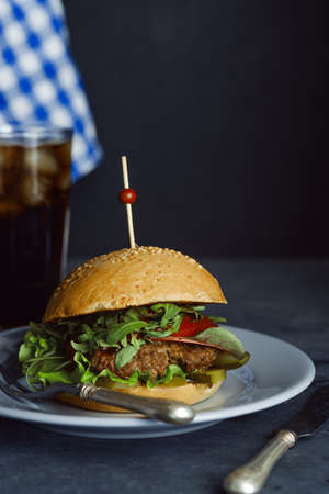 Burger with beef and fresh herbs on a dark table. Rustic soul style.の写真素材
