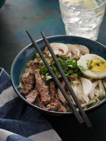 Asian ramen soup with beef, egg, chives, mushrooms in bowlの写真素材