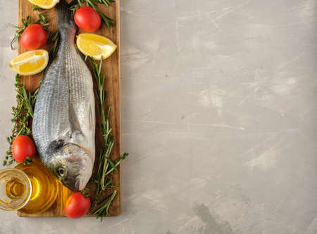 Fresh Raw Dorado with lemon, thyme, cherry and rosemary. Copyspace.