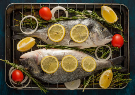 Fresh Raw Dorado with lemon, thyme, cherry and rosemaryの写真素材