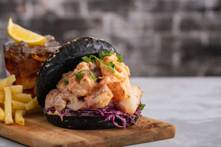 Black burger with fish and shrimps. Fishburger with prawns.の写真素材
