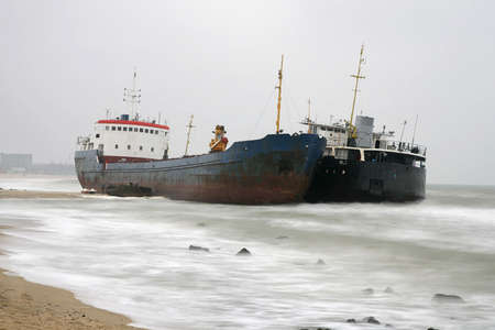 Two small ships are thrown by a storm on the shore near Odessa, Ukraineの写真素材