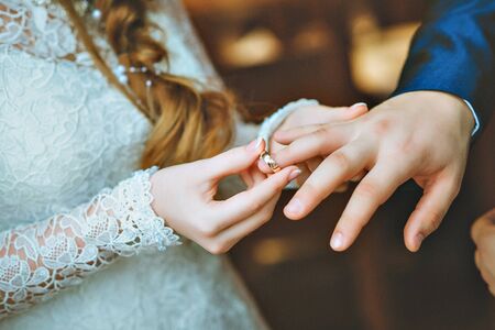 The groom wears the ring bride. Engagement. Wedding day. Wedding ring.の写真素材