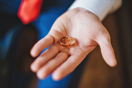 gold wedding rings at the wedding in man's handsの写真素材