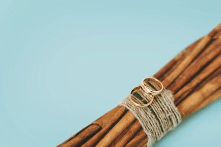 Blue background with wedding rings. Rings on wooden sticks