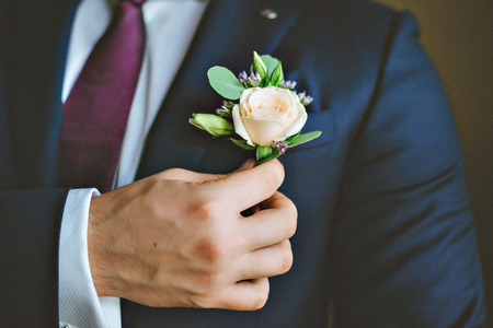 White freesia wedding boutonniere on suit of groom.の写真素材