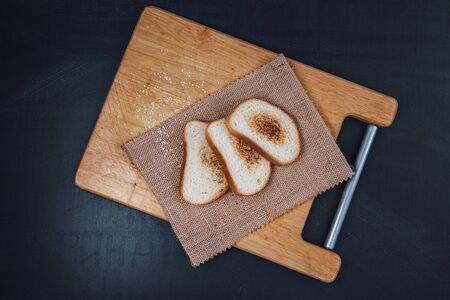 Toast baguette on slate. The toasted bread. The bread is white on a black background. Bread on wooden backgroundの写真素材
