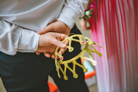 Man's hand holding golden crown. crown in the hand of men
