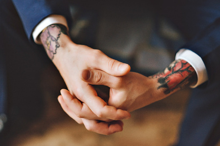 A man's hand in the tattoo. The man in the suit. Blue jacket. Hands close up of young tattooed man portrait. Hipster styleの写真素材