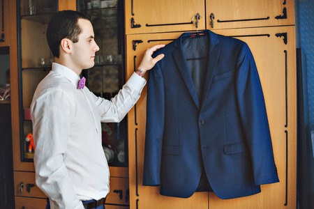 The man holding the jacket. The groom in shirt, jacket and serenity bow tie. Blue jacket. Hands tattooedの写真素材