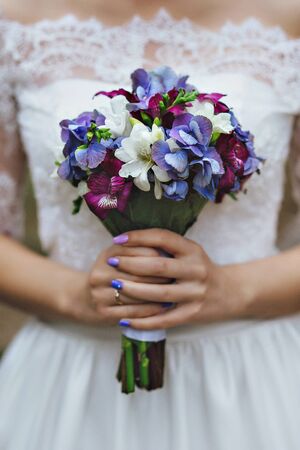 bride in a white dress holding a wedding bouquet of flowers.の写真素材