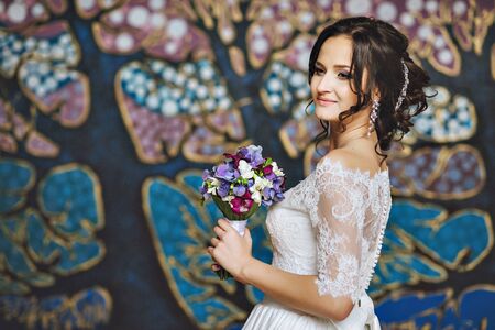 Portrait of woman with curly hairstyle and beautiful makeup looking down. Portrait of the bride looking down. Beautiful young brunette. Laceの写真素材