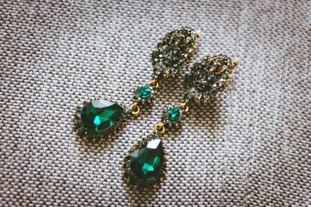 Earrings with green gemstone. Beautiful jewelry. Aged goldの写真素材