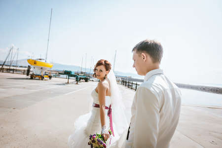 newlyweds walk, the groom holds a white train wedding dresses.の写真素材