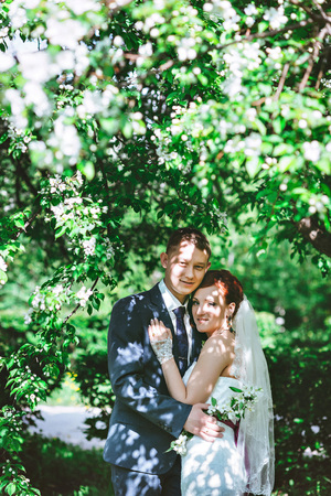 The couple in the Apple trees, looking at the camera, a flowering white treeの写真素材