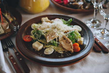Organic caesar salad in wodden bowl with caesar dressing. International food.の写真素材