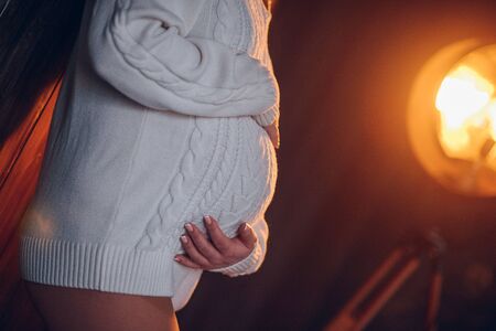 The woman hugs your pregnant belly. Romanceの写真素材