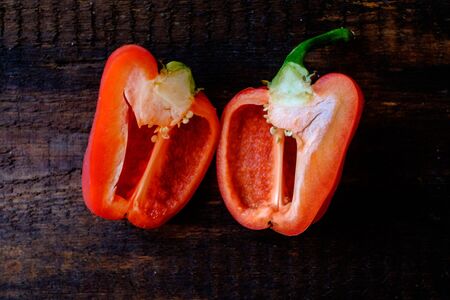 Fresh red bell peppers on a dark wooden background. Vegetarian food