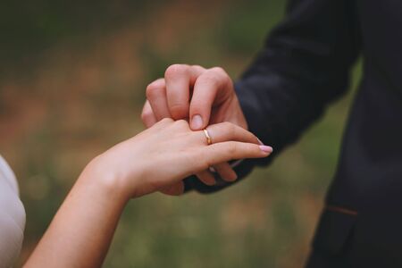 Wedding day. The groom places the ring on the bride's hand. Photo closeupの写真素材