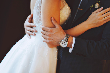 Hands of the bride and groom. A man hugs a woman. Watchの写真素材