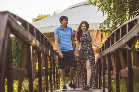 Happy romantic couple in the village, stroll on the wooden bridgeの写真素材
