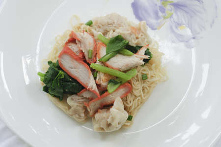 Delicious Asian egg noodles with barbecued red pork, dumplings and vegetables  