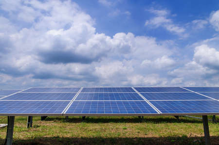 Solar panels in green field and sky
