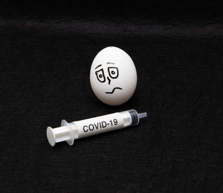 covid-19 and coronavirus eggs drawn frightened faces alcohol syringeの写真素材