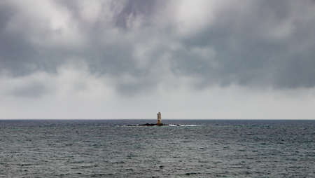 The lighthouse of the Mangiabarche shrouded by the waves of a mistral wind stormの写真素材
