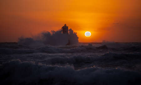 The lighthouse of the Mangiabarche shrouded by the waves of a mistral wind storm