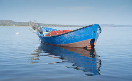 Boat in the water. Fishing boat in the calm waters of the pond of santa caterina in southern...
