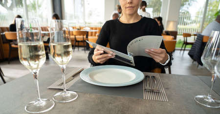 woman reading the menu in restaurantの写真素材