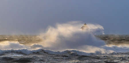 The lighthouse of the Mangiabarche shrouded by the waves of a mistral wind stormの写真素材