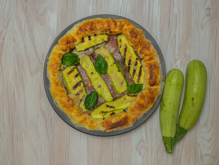 savory pie with courgettes and basil on a round plateの写真素材
