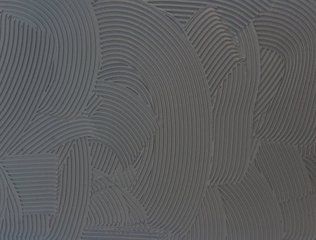 Cement wall cementitious adhesive applied to the floor.Modern gray background with curved lines