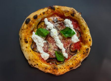 Neapolitan pizza with edges, chilli spices tomatoes and mozzarella on a dark background. Pizza with...