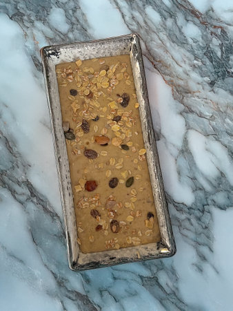 Homemade granola with nuts and raisins in a metal tray