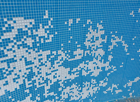 Damaged mosaic tiles falling into empty swimming pool preparations for renovationの写真素材