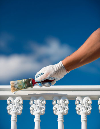 Home Renovation Concept: Painting an Ornate Balcony Railing in Bright Daylightの写真素材