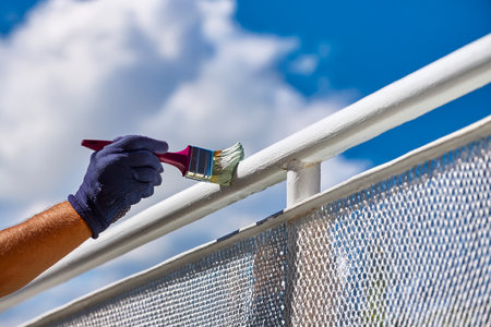 Home Renovation Concept: Painting an Ornate Balcony Railing in Bright Daylightの写真素材